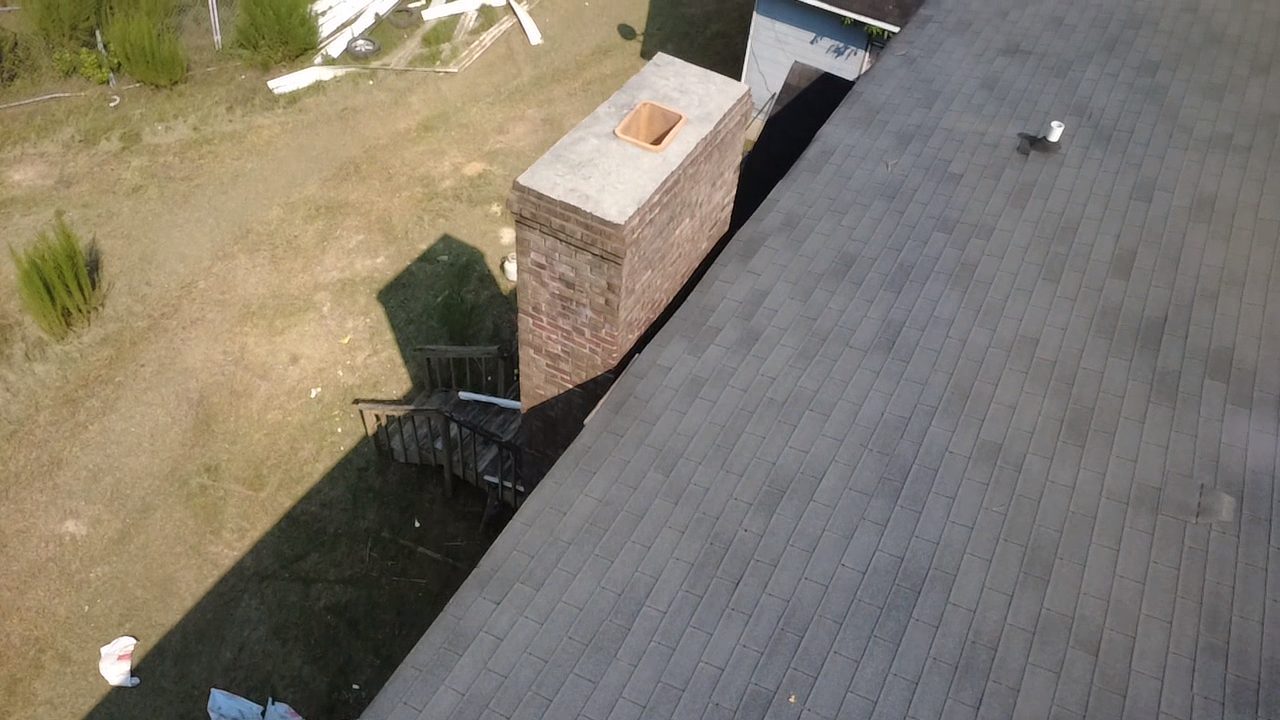Drone photo of chimney flashing and crown during a Vest Construction roof inspection