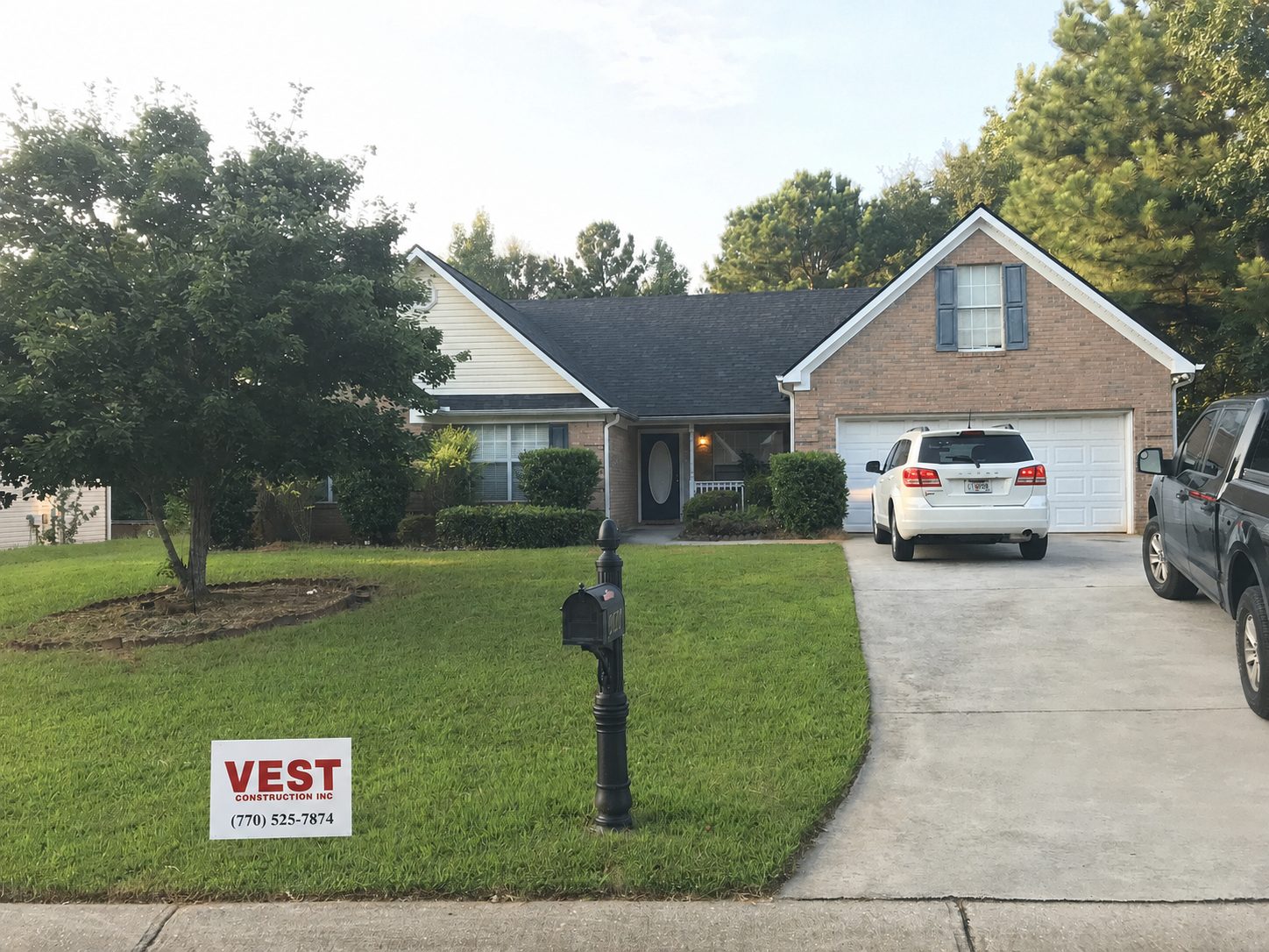 Completed Vest Construction shingle roof on a Georgia home with a Vest yard sign