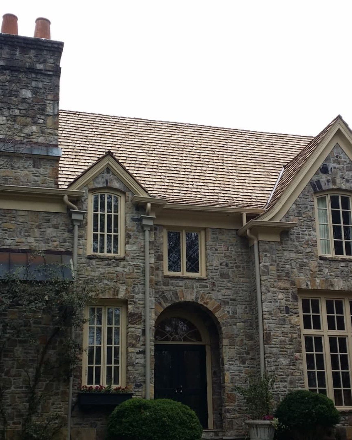 Stone Tudor home with new cedar shake roof in North Atlanta
